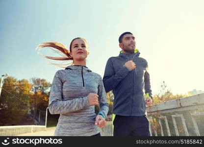 fitness, sport, people and lifestyle concept - happy couple running outdoors. happy couple running outdoors