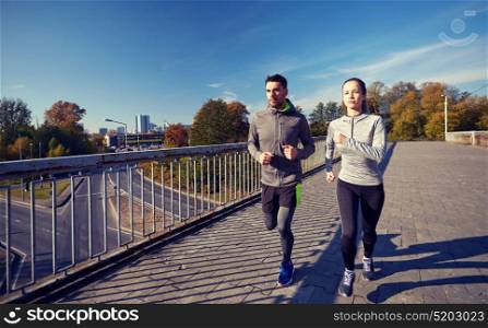 fitness, sport, people and lifestyle concept - happy couple running outdoors. happy couple running outdoors