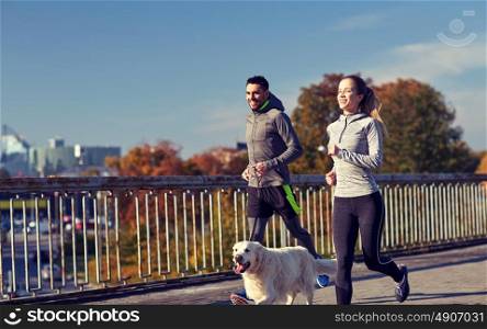 fitness, sport, people and lifestyle concept - happy couple with dog running outdoors. happy couple with dog running outdoors
