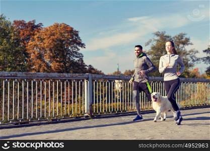 fitness, sport, people and lifestyle concept - happy couple with dog running outdoors. happy couple with dog running outdoors