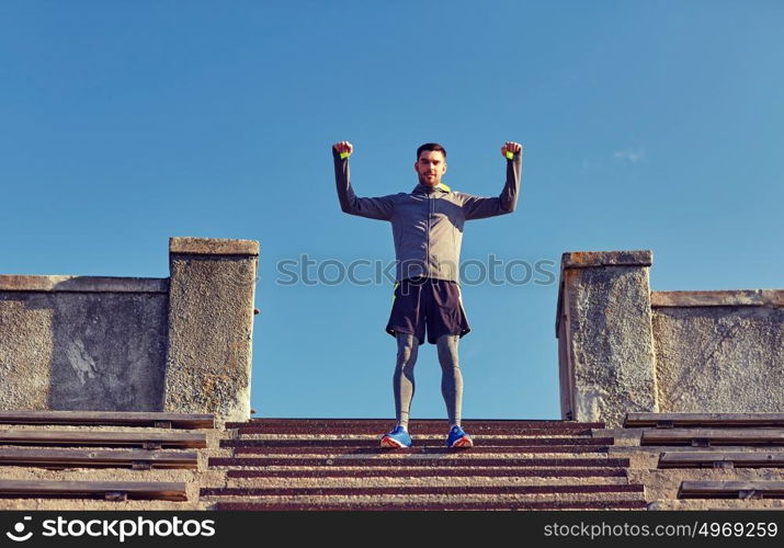 fitness, sport, people and lifestyle concept - happy man on stadium stair. happy man on stadium stair