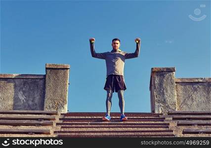 fitness, sport, people and lifestyle concept - happy man on stadium stair. happy man on stadium stair