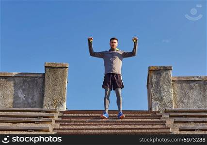 fitness, sport, people and lifestyle concept - happy man on stadium stair