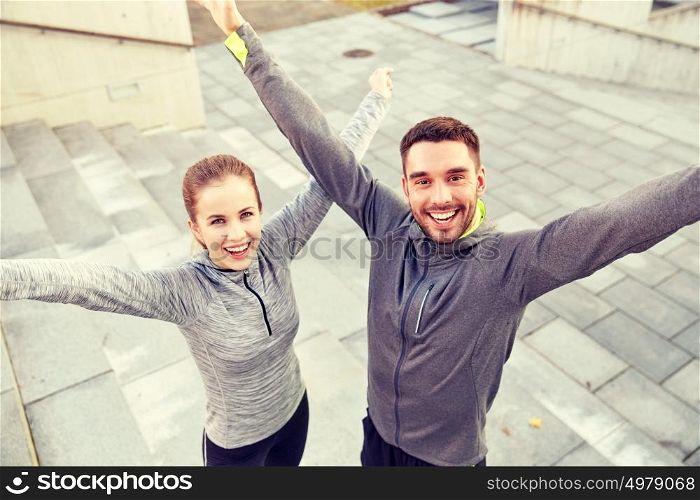 fitness, sport, people and lifestyle concept - happy smiling couple outdoors on city street. happy smiling couple outdoors on city street