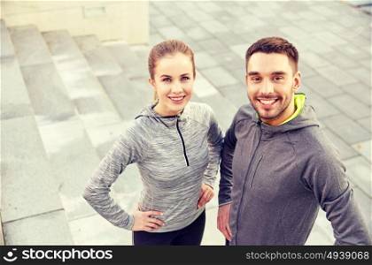 fitness, sport, people and lifestyle concept - smiling couple outdoors on city street. smiling couple outdoors on city street