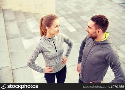 fitness, sport, people and lifestyle concept - smiling couple outdoors on city street. smiling couple outdoors on city street