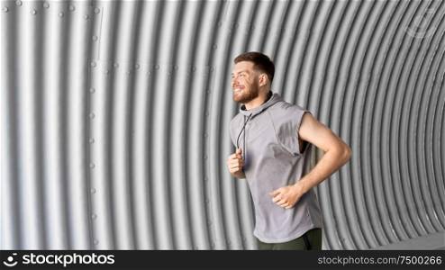 fitness, sport, people and lifestyle concept - sporty young man running in tunnel. sporty young man running in tunnel