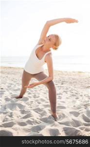 fitness, sport, people and lifestyle concept - young woman making yoga exercises on beach