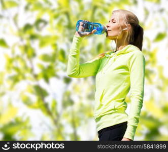 fitness, sport, people and thirst concept - happy woman drinking bottle water after doing sports over green tree leaves background