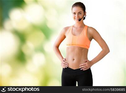 fitness, sport, people and training concept - female sports trainer with microphone woman over green natural background