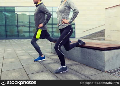 fitness, sport, people, exercising and lifestyle concept - close up of couple couple doing lunge exercise on city street. close up of couple doing lunge exercise on street
