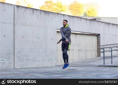 fitness, sport, people, exercising and lifestyle concept - man skipping with jump rope outdoors