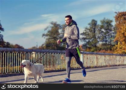 fitness, sport, people, pets and lifestyle concept - happy man with labrador retriever dog running outdoors. happy man with labrador dog running outdoors