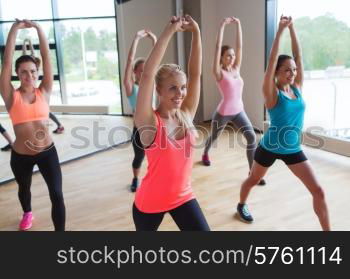 fitness, sport, people, teamwork and lifestyle concept - group of women working out in gym