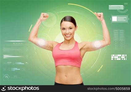 fitness, sport, power, technology and people concept - happy sporty young woman showing biceps over green background. happy sporty woman showing biceps