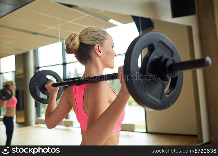 fitness, sport, powerlifting and people concept - sporty woman exercising with barbell in gym