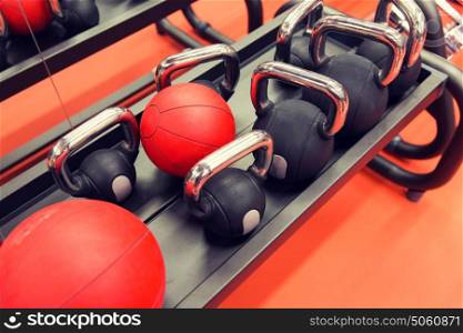 fitness, sport, sports equipment, weightlifting and bodybuilding concept - close up of kettlebells and medicine ball in gym. close up of kettlebells and medicine ball in gym