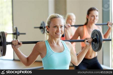 fitness, sport, training and lifestyle concept - group of happy women with barbells exercising in gym