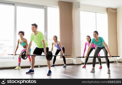 fitness, sport, training and lifestyle concept - group of people exercising with barbell bars in gym