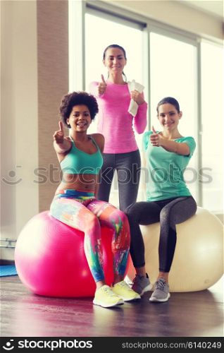 fitness, sport, training and lifestyle concept - group of smiling women with exercise balls in gym