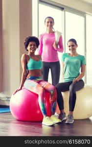 fitness, sport, training and lifestyle concept - group of smiling women with exercise balls in gym