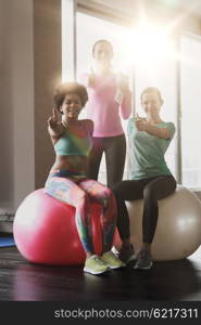 fitness, sport, training and lifestyle concept - group of smiling women with exercise balls in gym