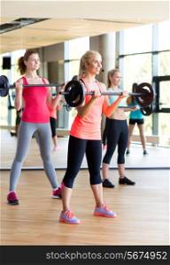 fitness, sport, training and lifestyle concept - group of women with barbells in gym