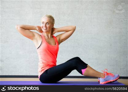 fitness, sport, training and lifestyle concept - smiling woman doing exercises on mat in gym