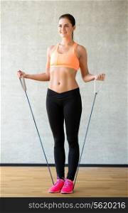 fitness, sport, training and lifestyle concept - smiling woman doing exercises with expander in gym
