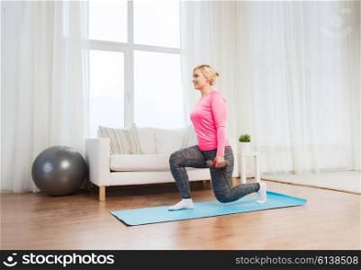 fitness, sport, training and lifestyle concept - smiling woman with dumbbells exercising and doing squats at home