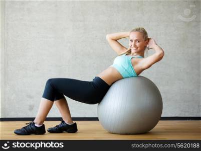 fitness, sport, training and lifestyle concept - smiling woman with exercise ball in gym