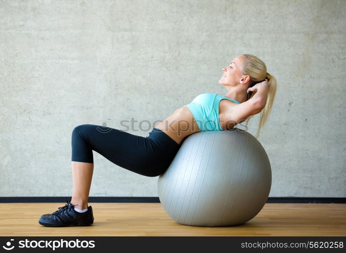 fitness, sport, training and lifestyle concept - smiling woman with exercise ball in gym