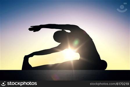 fitness, sport, training and lifestyle concept - woman exercising and stretching on stairs over sun light background
