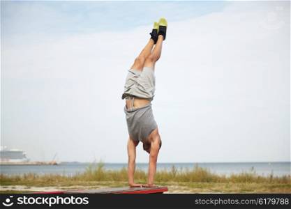 fitness, sport, training and lifestyle concept - young man exercising on bench outdoors