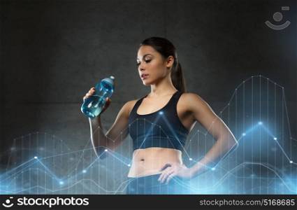 fitness, sport, training, drink and lifestyle concept - woman drinking water from bottle in gym. woman drinking water from bottle in gym