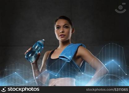 fitness, sport, training, drink and lifestyle concept - woman with towel drinking water from bottle in gym. woman with towel drinking water from bottle in gym