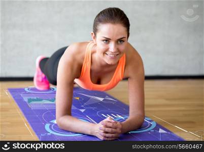 fitness, sport, training, future technology and lifestyle concept - smiling woman doing exercises on mat in gym over graph projection