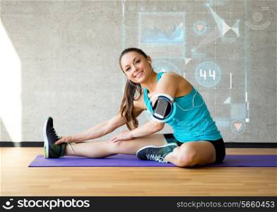 fitness, sport, training, future technology and lifestyle concept - smiling woman stretching leg on mat in gym over graph projection