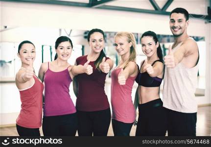 fitness, sport, training, gym and lifestyle concept - group of happy people in the gym showing thumbs up