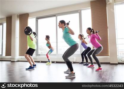fitness, sport, training, gym and lifestyle concept - group of people exercising with barbell and bars in gym