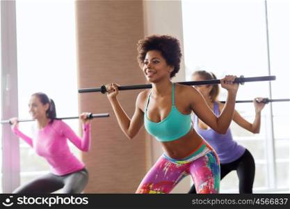 fitness, sport, training, gym and lifestyle concept - group of people exercising with bars in gym
