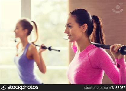 fitness, sport, training, gym and lifestyle concept - group of people exercising with bars in gym