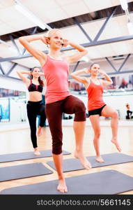 fitness, sport, training, gym and lifestyle concept - group of smiling female with trainer exercising in the gym