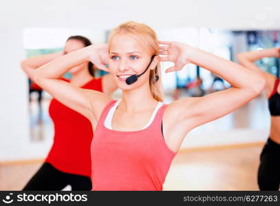 fitness, sport, training, gym and lifestyle concept - group of smiling people with trainer exercising in the gym