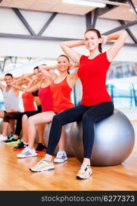 fitness, sport, training, gym and lifestyle concept - group of smiling people working out in pilates class