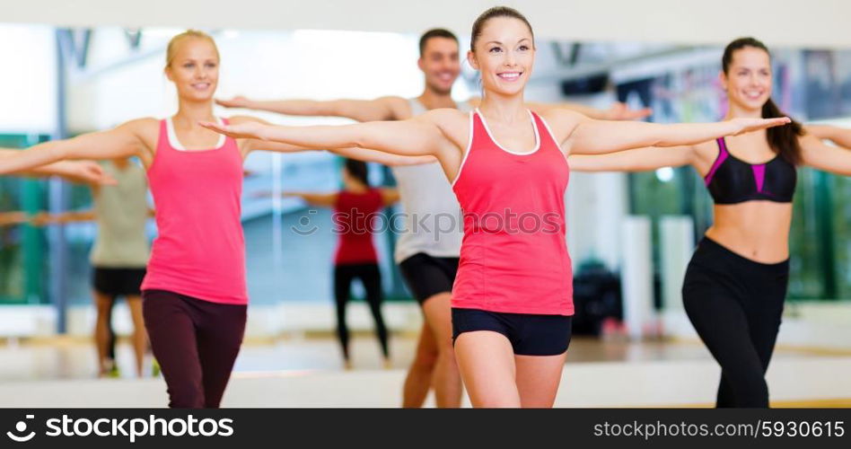 fitness, sport, training, gym and lifestyle concept - group of smiling people exercising in the gym
