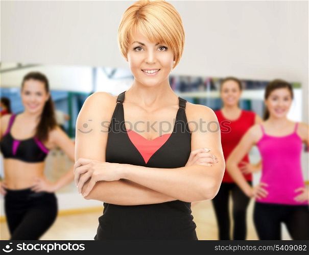 fitness, sport, training, gym and lifestyle concept - group of smiling women with trainer exercising in the gym