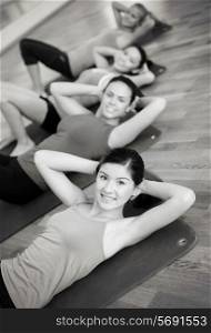 fitness, sport, training, gym and lifestyle concept - group of smiling women exercising on mats in the gym