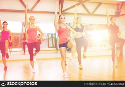 fitness, sport, training, gym and lifestyle concept - group of smiling women exercising in the gym