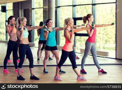fitness, sport, training, gym and lifestyle concept - group of women with dumbbells in gym